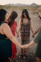 women's group standing together holding hands in prayer 