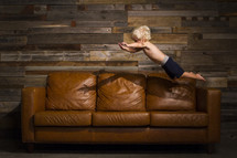 a boy child jumping onto a couch