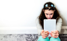 teen girl looking at an iPad screen 