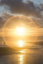 halo of sunlight and a family on a beach 