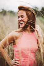 Smiling woman standing in a wheat field.