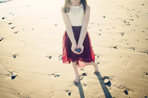 girl holding a rock on a beach 
