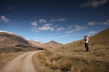 A photographer near a country road.