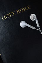Holy Bible and earbuds 
