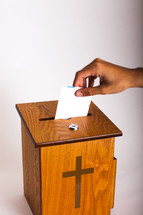placing an envelope in the offering box 