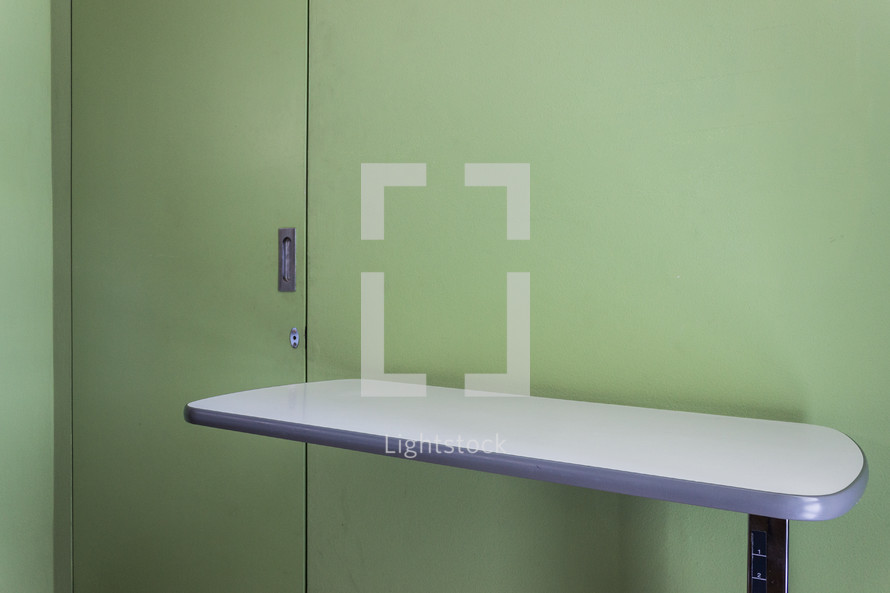 table and green doors in a hospital room 