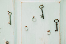 keys and wedding rings hanging on a wall