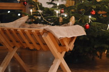 manger in front of a Christmas tree in a house 