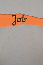 torn open kraft paper over orange paper with the name of the book Job