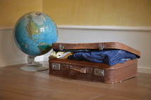 a globe and a packed suitcase 