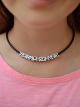 CHILD OF GOD written on pearls at a necklace around a kids neck 