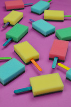 multicolored sponge popsicles on pink background as thank you for the volunteer cleaning team in church or as decoration for the vacation bible school in the classroom
