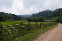 wood fence along a dirt road in the jungles of Myanmar