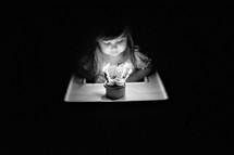a toddler girl blowing out candles in a cupcake 