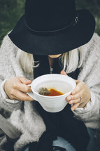 a woman holding a mug of tea 