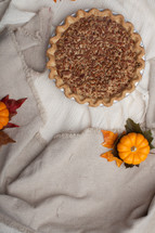a pecan pie on a tablecloth 