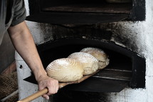 freshly baked bread out of an old timey wood fired oven, 
bread, food, oven, fresh, ancient, nourishment, eat, need, hunger, satisfaction, consume, meal, eating, feeding, daily, loaf, life, live, woodstove, wood, wood burner, wood fired oven, wood-burning stove, wood-fired, fired, fire, burn, burning, flame, flames, hot, bake, baking, baker, bakery, antique, archaic, antiquarian, antiquated, old-world, medieval, mediaeval, medievally, mediaevally, originally, original, native, freshly, peel, baker's peel, bread peel, pray, prayer, Lord's prayer