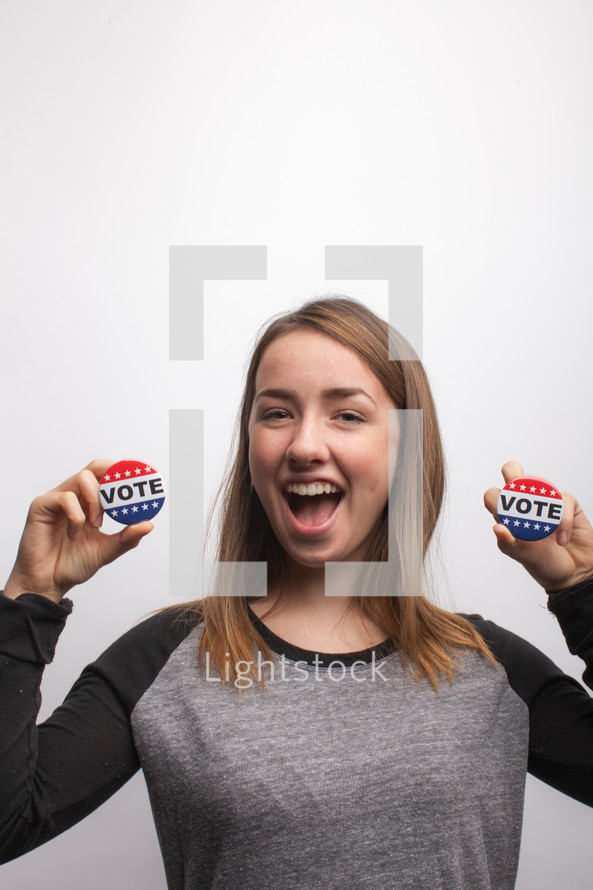 young woman holding vote button 