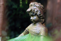 Iron garden statue of a little girl.