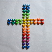 Many small, different colored hearts in the shape of a cross.
