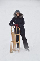 woman standing with a sled in snow 