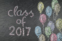 chalk on slate with balloons and the words: class of 2017 