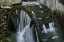 water flowing over a water wheel at a mill 