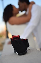 infant shoes in front of a couple kissing 