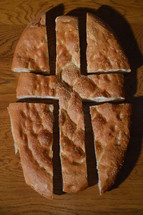 Bread broken into pieces showing the shape of a cross. 
