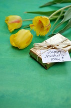 yellow tulips and a wrapped mother's day gift 
