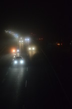 View from a bridge at a highway by night on a cold foggy winter night. 
