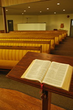Bible at the pulpit and rows of church pews 