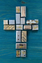 many little presents shaping a cross on teal wooden background