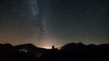 Milky way stars in starry night sky over rural country and fence in summer landscape time-lapse astronomy
