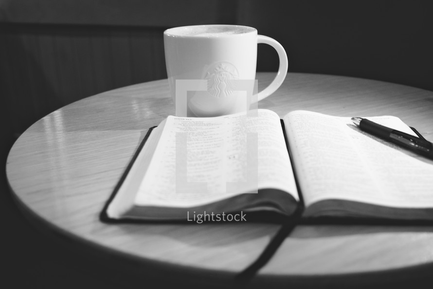 Open bible next to coffee mug
