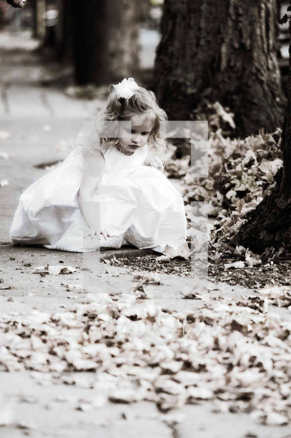 Young girl touching leaves in the park