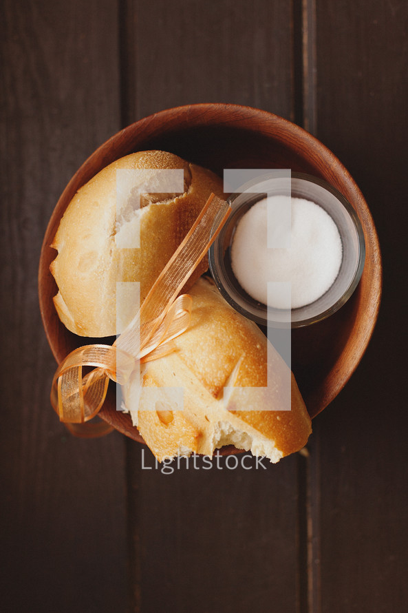 Broken loaf of bread and butter in bowl