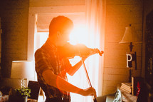 teen boy playing a fiddle 