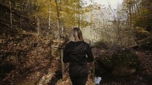 a woman walking in a forest in fall 