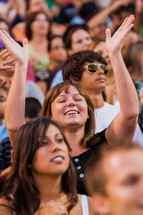 Church service woman raising hands in worship eyes closed crusade
