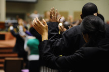 hands raised in worship at a church service 