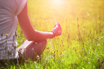 a woman mediating in the grass