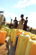 row of water canisters in Africa
