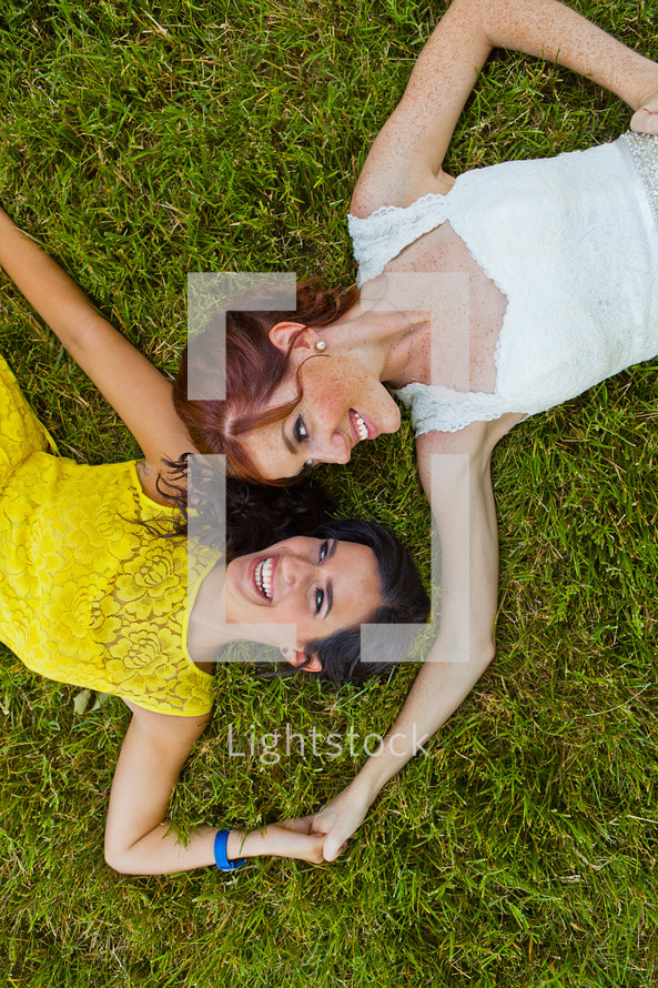 adult sisters lying on the grass