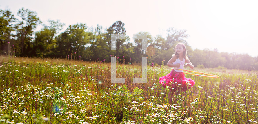 little girl dancing in a field of wild flowers