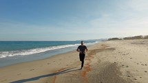 Determined Man Runs On The Beach To Achieve His Goals