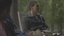 young men discussing scripture on a cabin porch 