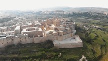 Panoramic view outside the Mdina city fortifications of Metropolitan Cathedral of Saint Paul - Fly-forward aerial shot