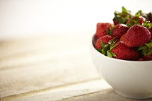A bowl of strawberries  on a table