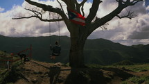 swinging on a tree swing on a mountaintop 